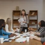 woman in gray blazer doing a report