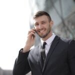 man in black suit jacket holding smartphone
